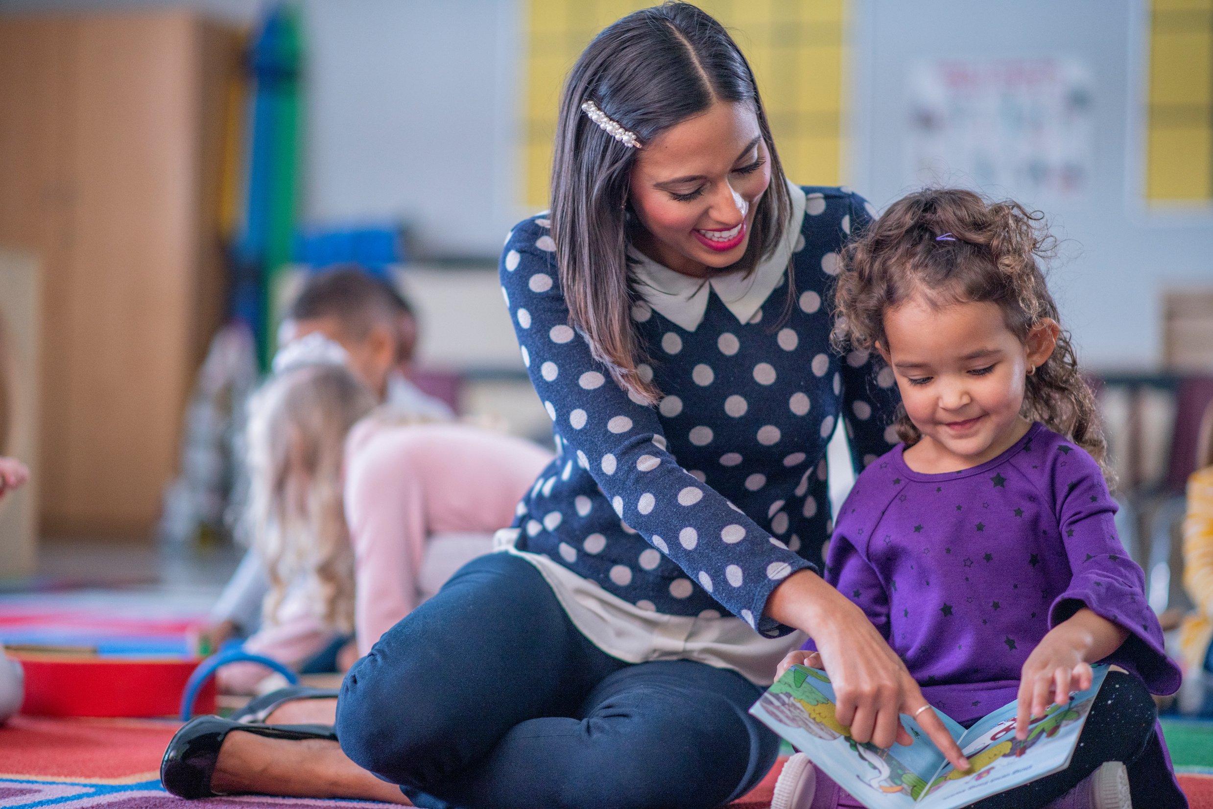 Child and Teacher Reading Together stock photo