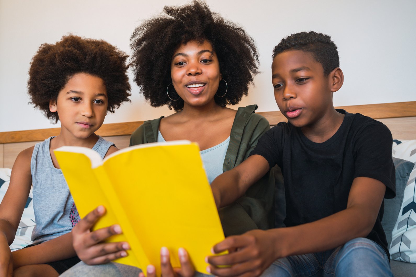 Mother Reading Book with Her Children at Home